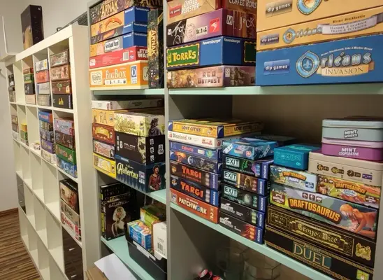 Ein Bild von zwei Regalen, in welchen eine Vielzahl von Spielen gelagert sind, darunter diverse Exit Games, Orleans inklusive Erweiterungen, Dune Imperium und viele Andere.